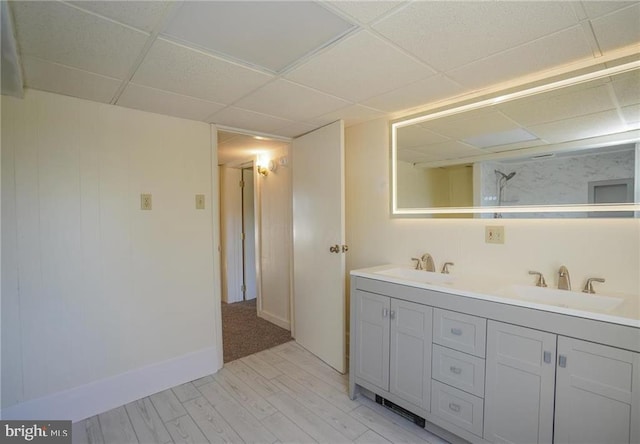 bathroom featuring a paneled ceiling, vanity, and wood-type flooring