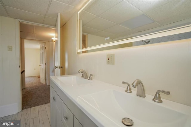 bathroom featuring a drop ceiling, vanity, and wood-type flooring