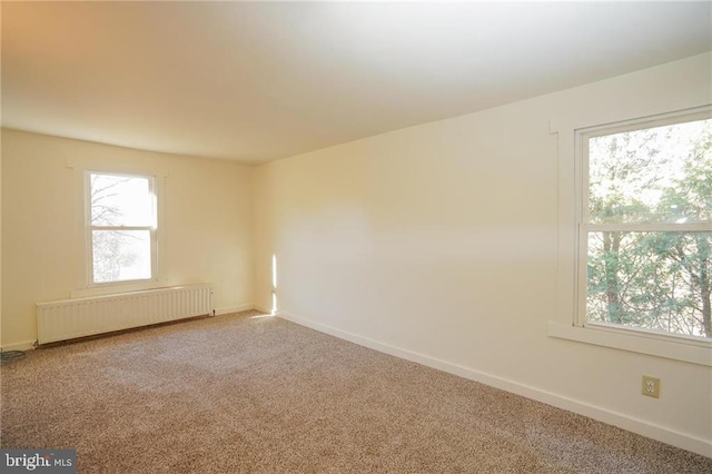 spare room with carpet flooring and radiator