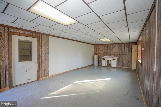 basement with wooden walls and electric water heater