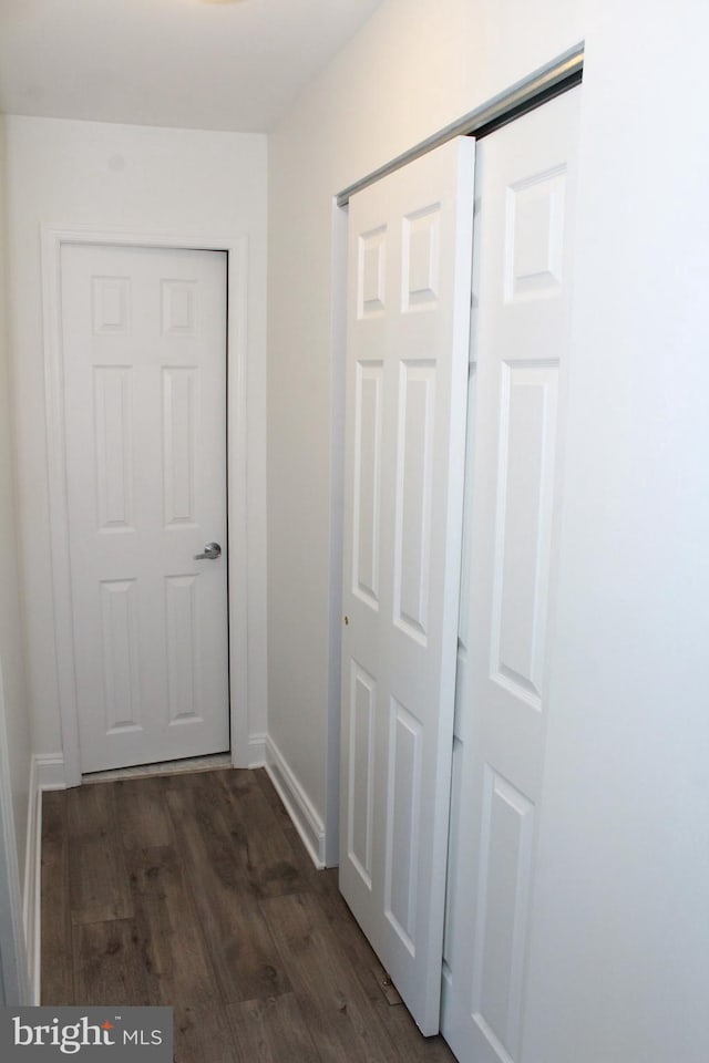 corridor with dark hardwood / wood-style flooring