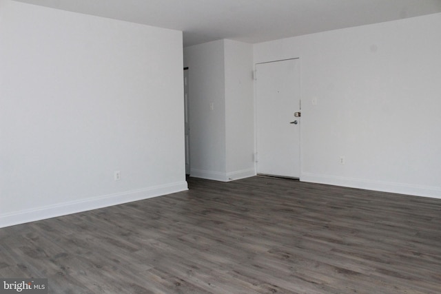 unfurnished room with dark wood-type flooring