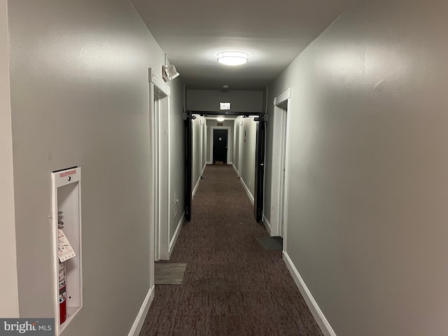 hall featuring dark colored carpet