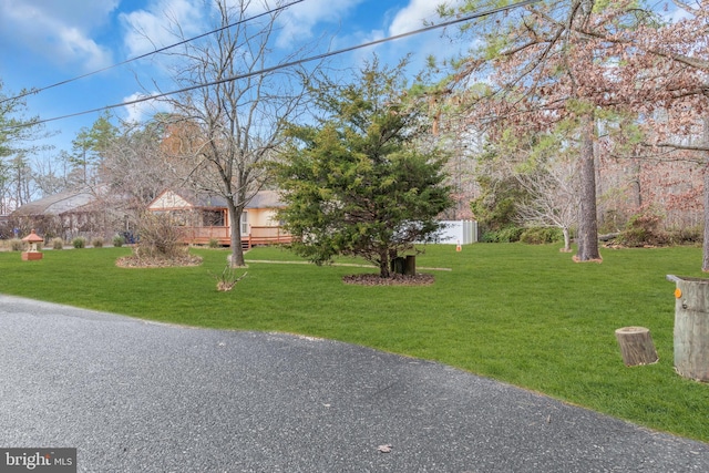 exterior space featuring a wooden deck and a front yard