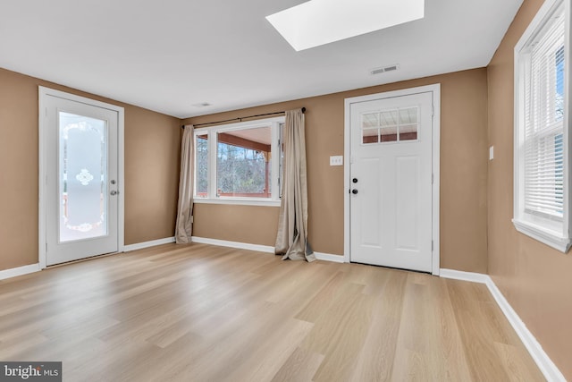 entryway with a skylight and light hardwood / wood-style flooring