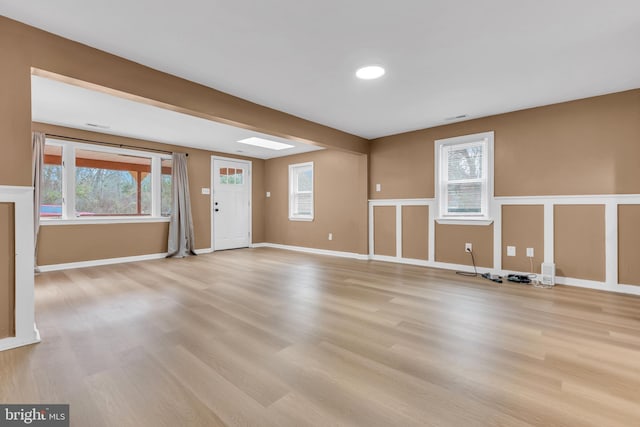 spare room with light wood-type flooring and plenty of natural light