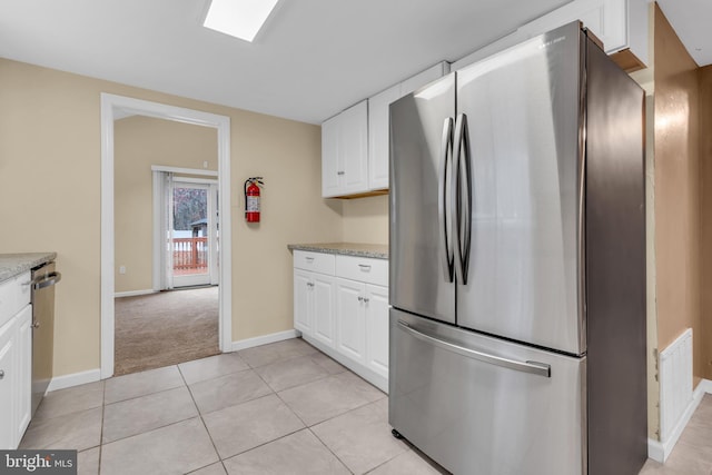 kitchen featuring light colored carpet, light stone counters, white cabinetry, and stainless steel appliances