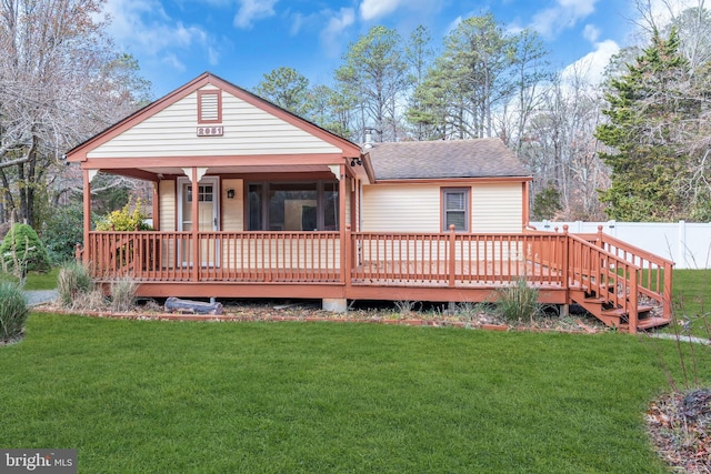 rear view of house featuring a yard