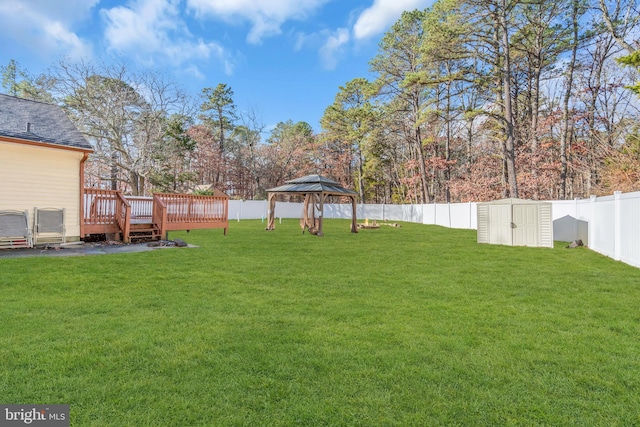 view of yard featuring a gazebo, a storage shed, and a deck