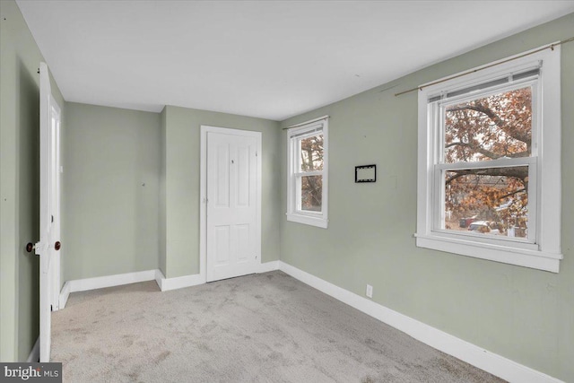 unfurnished bedroom featuring light colored carpet and a closet