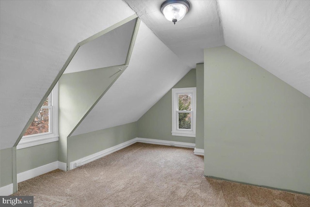 additional living space with light carpet and vaulted ceiling