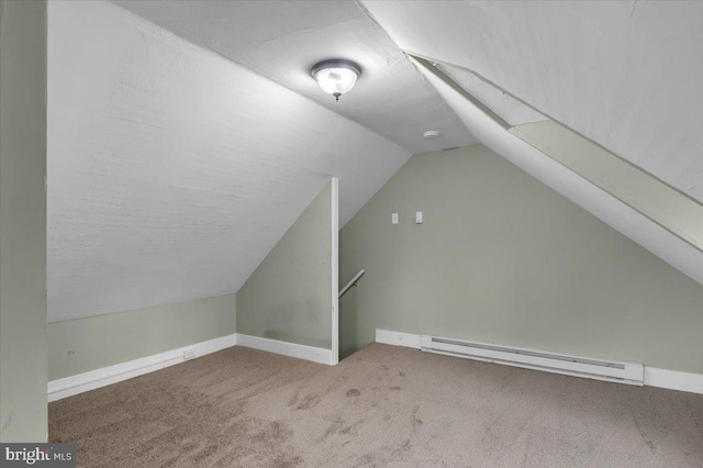 additional living space featuring vaulted ceiling, light colored carpet, and a baseboard radiator