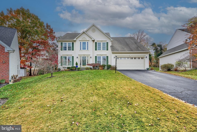 view of front of home with a garage and a front lawn