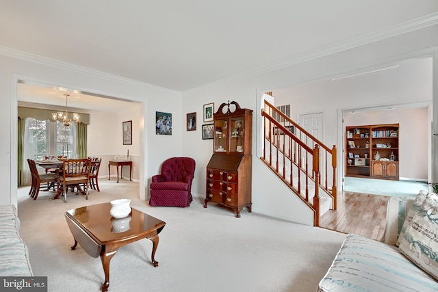 carpeted living room with a notable chandelier and ornamental molding