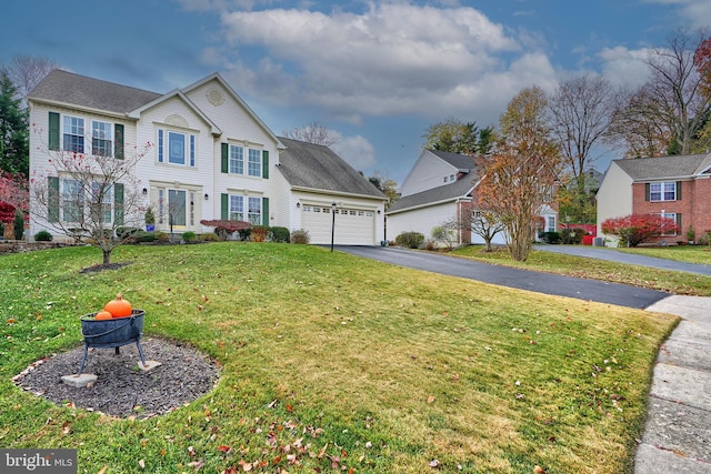 view of front of home with a front yard and a garage