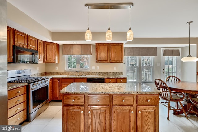 kitchen featuring sink, light tile patterned floors, decorative light fixtures, a kitchen island, and black appliances