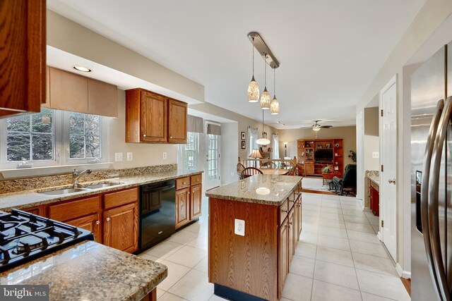 kitchen with ceiling fan, a center island, sink, hanging light fixtures, and stainless steel appliances