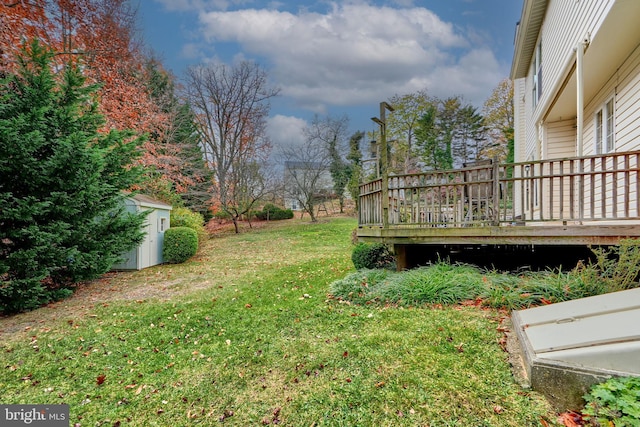 view of yard featuring a wooden deck and a storage shed