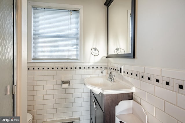 bathroom with vanity, tile walls, and toilet