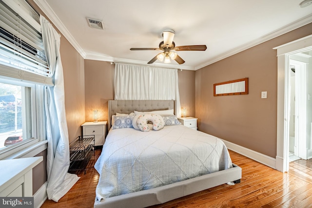 bedroom with hardwood / wood-style flooring, ceiling fan, and ornamental molding