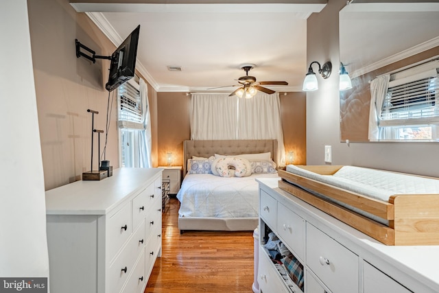 bedroom with multiple windows, light hardwood / wood-style flooring, ceiling fan, and crown molding