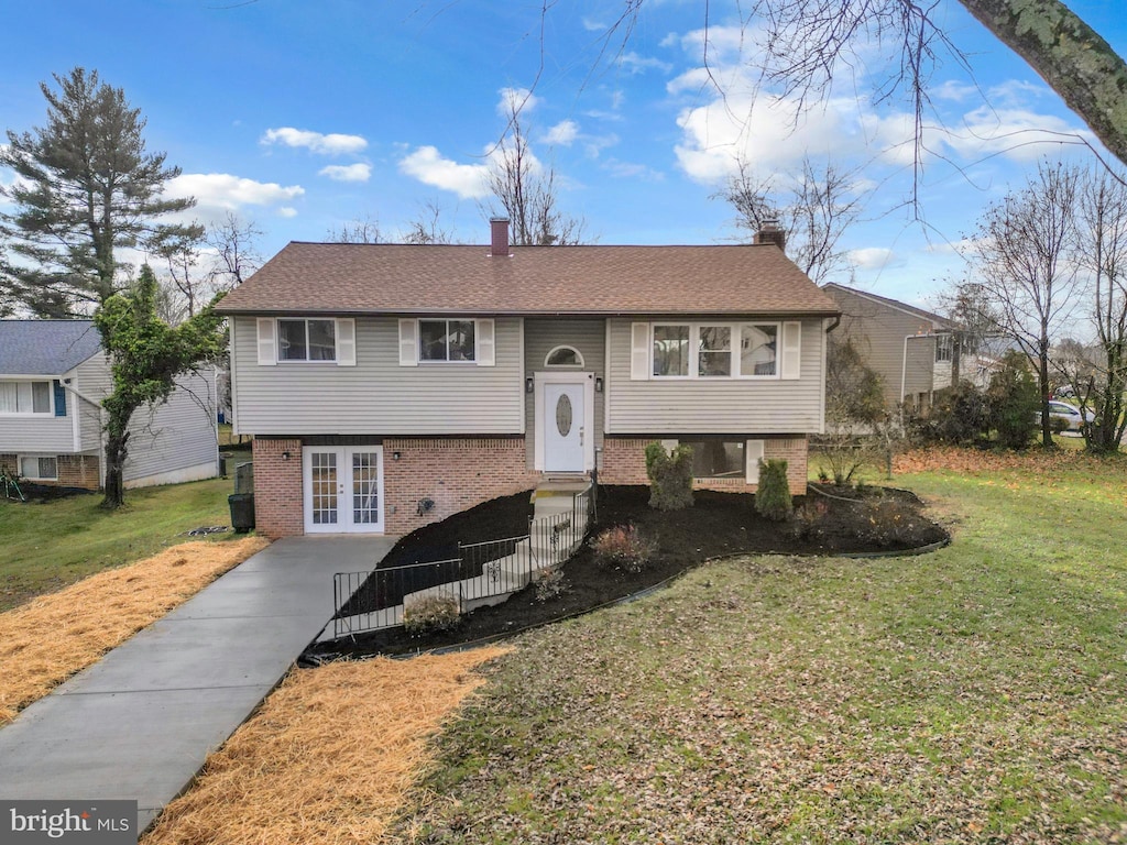 split foyer home with french doors and a front lawn