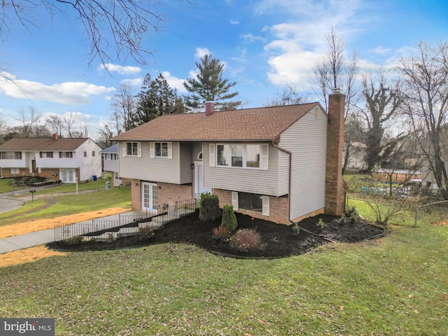 bi-level home featuring french doors and a front lawn