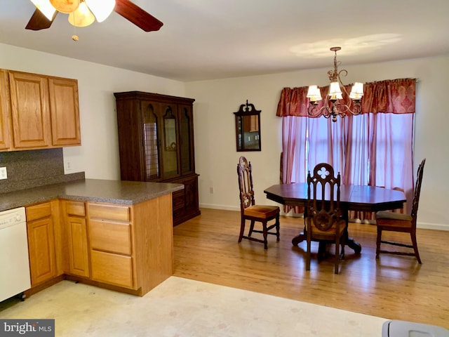 kitchen featuring kitchen peninsula, white dishwasher, pendant lighting, light hardwood / wood-style floors, and ceiling fan with notable chandelier