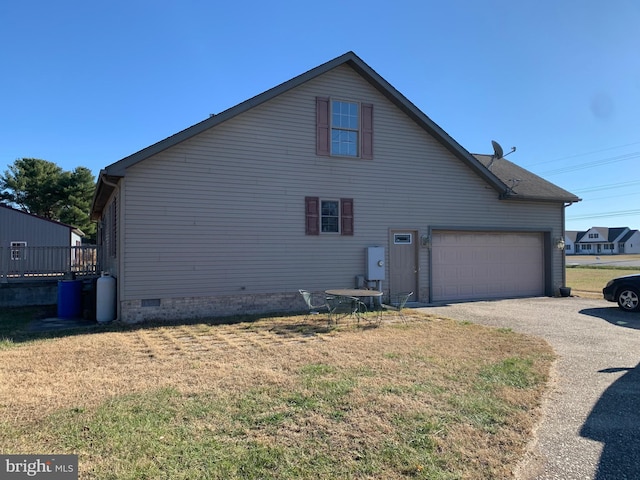 view of side of property featuring a lawn and a garage