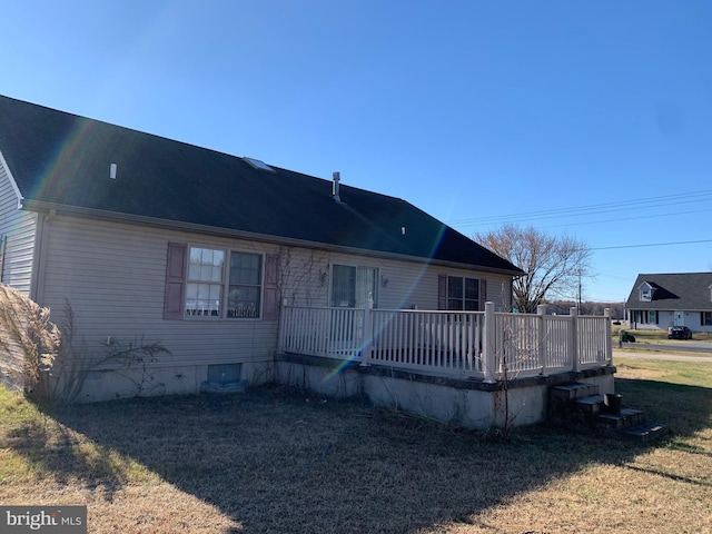 rear view of house with a lawn and a deck