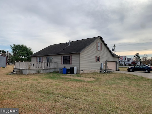 view of side of property with cooling unit, a garage, and a yard