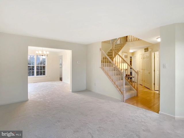 carpeted spare room with a chandelier