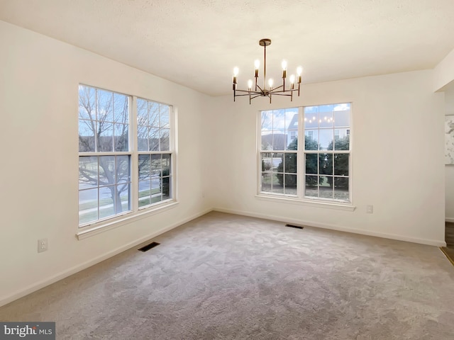 unfurnished dining area featuring carpet and a chandelier