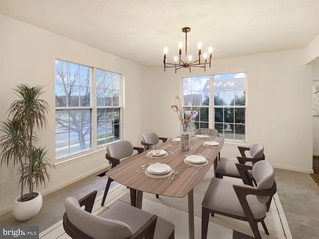 dining space featuring light colored carpet and a notable chandelier