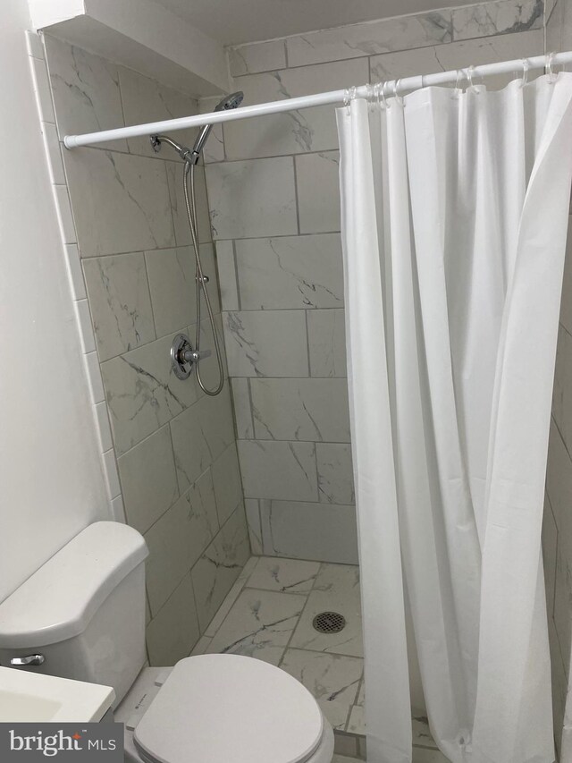 bathroom with toilet and curtained shower