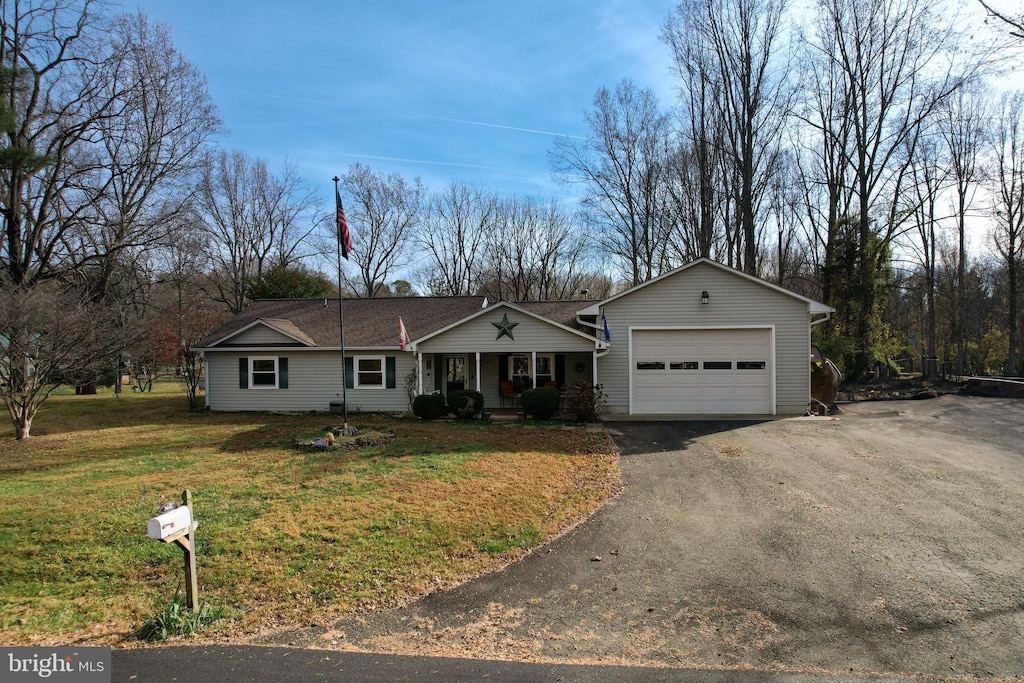 ranch-style home with covered porch, a garage, and a front lawn