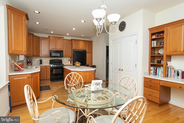 dining space featuring sink, light hardwood / wood-style floors, and a notable chandelier