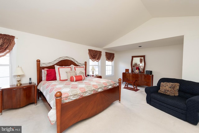 bedroom with light colored carpet, lofted ceiling, and multiple windows