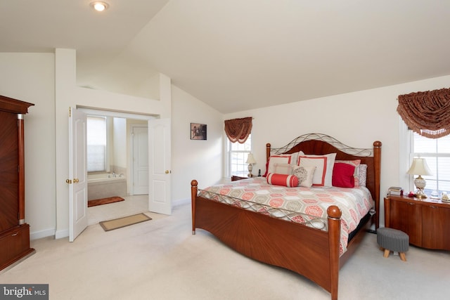 bedroom with multiple windows, ensuite bathroom, carpet floors, and lofted ceiling