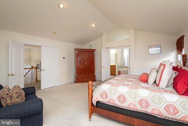 carpeted bedroom featuring ensuite bathroom, lofted ceiling, and a closet