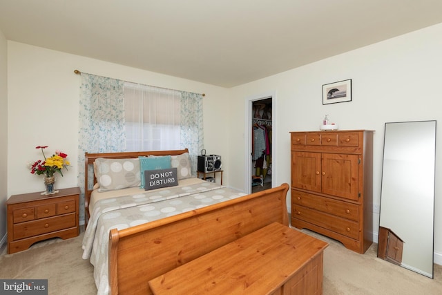 carpeted bedroom with a walk in closet and a closet