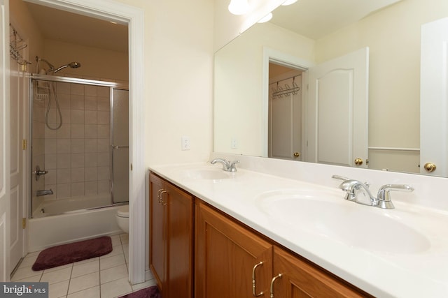 full bathroom featuring toilet, vanity, tile patterned floors, and enclosed tub / shower combo