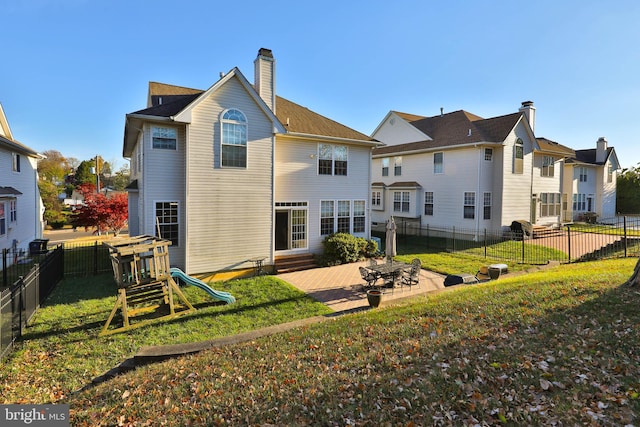 rear view of house with a yard, a playground, and a patio