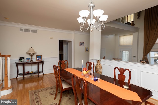 dining area with an inviting chandelier, light hardwood / wood-style flooring, and crown molding