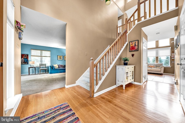 stairway featuring hardwood / wood-style floors and a high ceiling