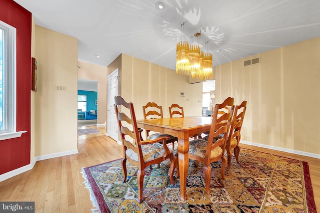 dining space featuring a chandelier and light hardwood / wood-style floors