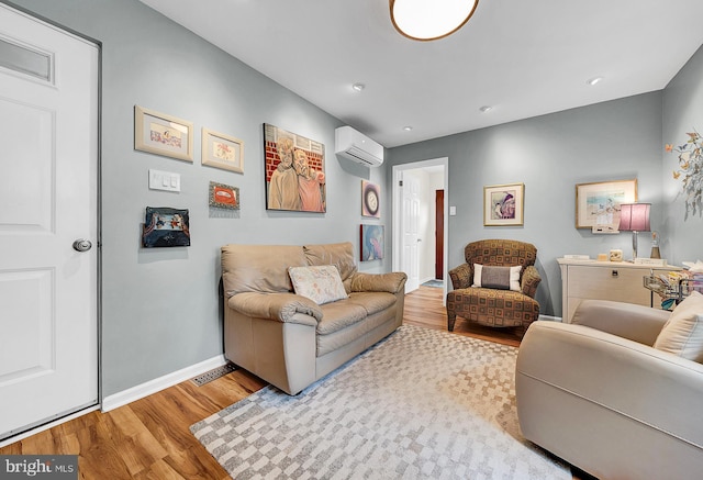 living room featuring a wall mounted air conditioner and light wood-type flooring