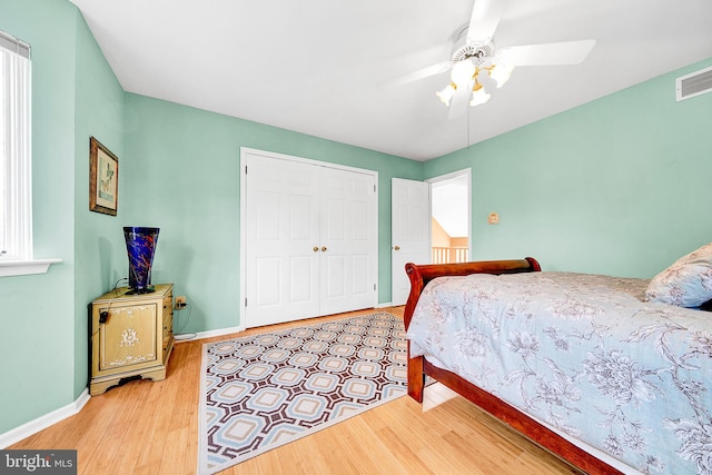 bedroom with ceiling fan, light wood-type flooring, and a closet