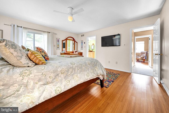 bedroom featuring ceiling fan, hardwood / wood-style floors, and ensuite bathroom