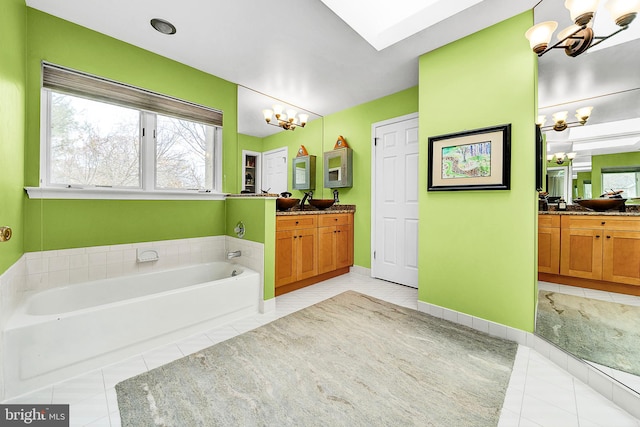 bathroom featuring tile patterned floors, a bathtub, vanity, and a chandelier